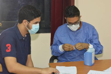 bir üniversite öğrencisi, Mısır üniversitelerinde aşı aşısı olur, akademik yıl boyunca personel olur, Mısırlı öğrencilerin koronavirüs aşısı olur.
