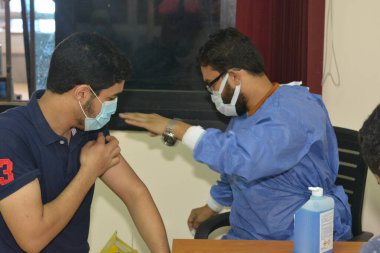 bir üniversite öğrencisi, Mısır üniversitelerinde aşı aşısı olur, akademik yıl boyunca personel olur, Mısırlı öğrencilerin koronavirüs aşısı olur.