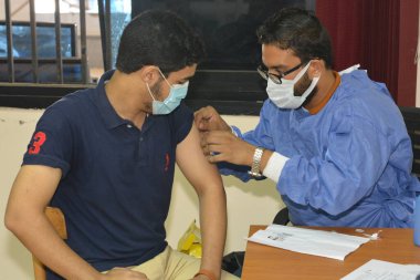 bir üniversite öğrencisi, Mısır üniversitelerinde aşı aşısı olur, akademik yıl boyunca personel olur, Mısırlı öğrencilerin koronavirüs aşısı olur.