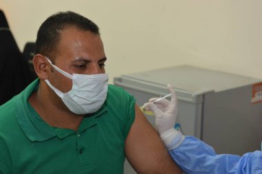 Kahire, Mısır. Eylül 12021: Tıbbi personel bir insana koronavirüs aşısı enjekte ediyor, COVID-2019 salgınına karşı virüs koruması, covid-19 salgınına karşı Coronavirus aşısı.