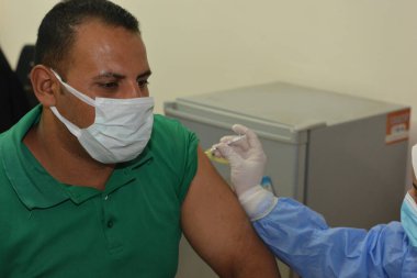 Kahire, Mısır. Eylül 12021: Tıbbi personel bir insana koronavirüs aşısı enjekte ediyor, COVID-2019 salgınına karşı virüs koruması, covid-19 salgınına karşı Coronavirus aşısı.