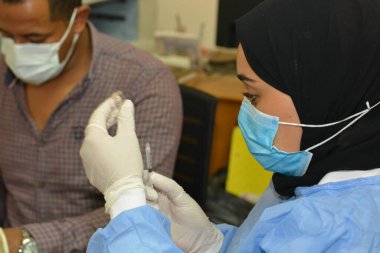 Kahire, Mısır. Eylül 12021: Sağlık personeli Coronavirus aşısı hazırlıyor, COVID-2019 'a karşı virüs koruması, salgın hastalığa karşı aşı, covid-19 salgınına karşı Coronavirus aşısı,