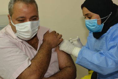 Kahire, Mısır. Eylül 12021: Tıbbi personel bir insana koronavirüs aşısı enjekte ediyor, COVID-2019 salgınına karşı virüs koruması, covid-19 salgınına karşı Coronavirus aşısı.