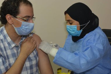 Kahire, Mısır. Eylül 12021: Tıbbi personel bir insana koronavirüs aşısı enjekte ediyor, COVID-2019 salgınına karşı virüs koruması, covid-19 salgınına karşı Coronavirus aşısı.