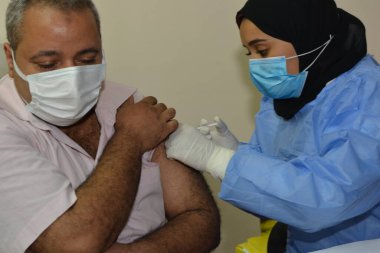 Kahire, Mısır. Eylül 12021: Tıbbi personel bir insana koronavirüs aşısı enjekte ediyor, COVID-2019 salgınına karşı virüs koruması, covid-19 salgınına karşı Coronavirus aşısı.