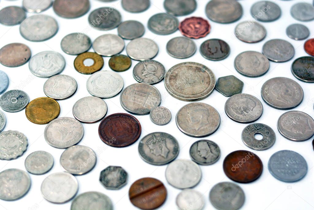Background of various coins from many countries and different values isolated on white background, vintage retro, selective focus of old coins currency from multiple countries and different times.