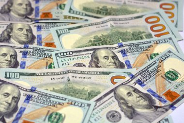 100 dolarlık banknot yığını, 100 Amerikan doları banknotlar üzerinde Benjamin Franklin 'in fotoğrafının olduğu banknot ve Philadelphia' daki Bağımsızlık Salonu 'nun tam tersi.