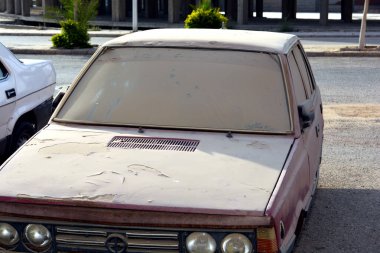 Eski unutulmuş paslı kirli bir araba. Zarar görmüş lastikleri, tozlu bozuk arabası, paslı enkazı, terk edilmiş arabası, grunge arkaplanı, antika geçmişi olan.