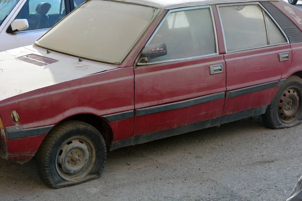 Eski unutulmuş paslı kirli bir araba. Zarar görmüş lastikleri, tozlu bozuk arabası, paslı enkazı, terk edilmiş arabası, grunge arkaplanı, antika geçmişi olan.