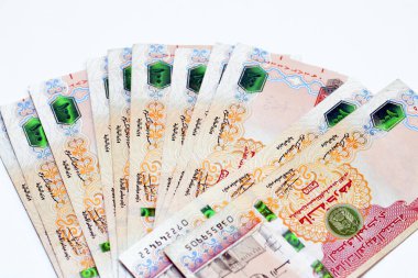 100 AED 'lik yığının seçici odak noktası Birleşik Arap Emirlikleri' nin 100 Dirhem banknot para birimi. Üzerinde Al Fahidi Fort 'un resmi var. Beyaz arka planda izole edilmiş bir yığın Emirlik parası. 