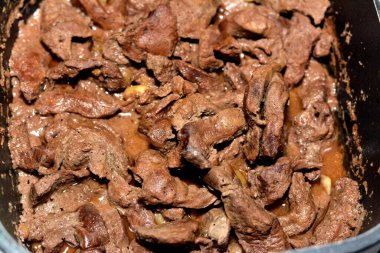 Parçalara ayrılmış ve yağlı, beyaz sirkeli, karabiberli, tuzlu, baharatlı, kişniş ve sarımsaklı, İskenderiye usulü karaciğer ve karaciğer ile pişirilmiş seçici et ciğeri.