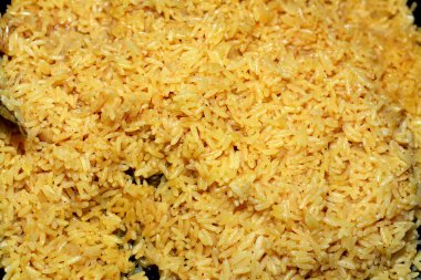 Uzun tahıllı sarı Basmati pilavının seçici odağı körfez defne, tuz, baharat, tarçın ve köri ile pişirilmiş sıcak buharda pişirilmeye hazır sıcak Hint pilavı.