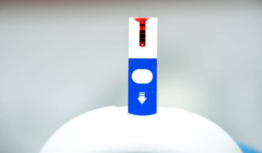 Evdeki diyabetik hastaları takip etmek ve onlar için ilaç dozlarını ve ilaçlarını ayarlamak için glikoz izleme cihazına yerleştirilmiş kullanılmış bir kan glikozu elektronik test şeridi, seçici odaklanma