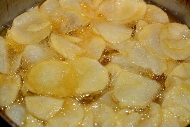 Evdeki fritözde kızgın yağda kızartılmış patates kızartması. Fast fries, Junk food konsepti, ev yapımı kızarmış cips, seçici odaklanma