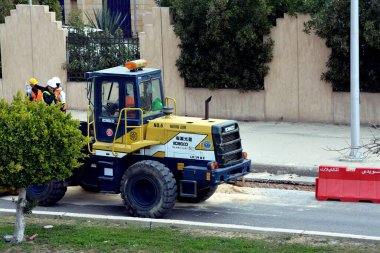 Giza, Mısır, 14 Mart 2022: Ağır sarı buldozer seçici odak noktası, gradyatör ve kazıcı inşaat ekipmanları, son yükleyici araç, buldozer ocağı, işçili taş tekerlek sarı kazıcı