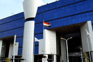 Kahire, Mısır, 20 Mart 2022: Mısır Üniversitesi 'nde Mısır bayrağıyla birlikte bir eczane binasının inşası, mavi bir binanın seçici odak noktası.