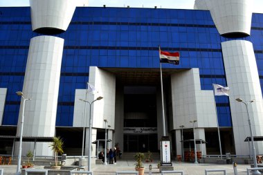 Kahire, Mısır, 20 Mart 2022: Mısır Üniversitesi 'nde Mısır bayrağıyla birlikte bir eczane binasının inşası, mavi bir binanın seçici odak noktası.