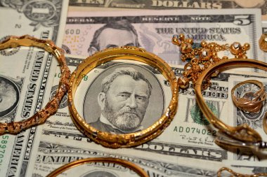 Bir dizi altın aksesuar yüzük, zincir ve bilezik Amerikan doları üzerine para, altın değer konsepti, mücevher alıcısı, rehin dükkanı, değerli metalleri alıp satma konsepti.