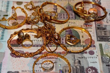  Mısır sterlinleri farklı değerlerdeki paraları altın aksesuarlar, kolye ve bilezikler ile altın değer konsepti, mücevher alıcısı, rehin dükkanı, değerli metalleri alıp satma konsepti ile finanse eder.