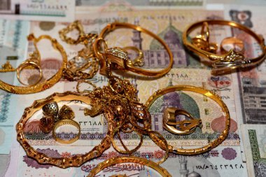  Mısır sterlinleri farklı değerlerdeki paraları altın aksesuarlar, kolye ve bilezikler ile altın değer konsepti, mücevher alıcısı, rehin dükkanı, değerli metalleri alıp satma konsepti ile finanse eder.