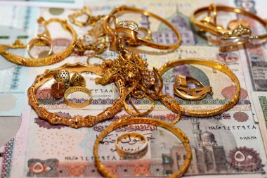  Mısır sterlinleri farklı değerlerdeki paraları altın aksesuarlar, kolye ve bilezikler ile altın değer konsepti, mücevher alıcısı, rehin dükkanı, değerli metalleri alıp satma konsepti ile finanse eder.