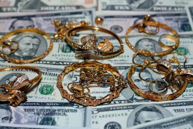 Bir dizi altın aksesuar yüzük, zincir ve bilezik Amerikan doları üzerine para, altın değer konsepti, mücevher alıcısı, rehin dükkanı, değerli metalleri alıp satma konsepti.