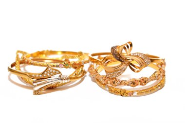 İzole edilmiş beyaz bir arka planda mücevher, bir dizi altın bilezik 21 karat tasarım altın mücevherler, değerli metal takılar, seçici bir odak noktası olan bileklik.