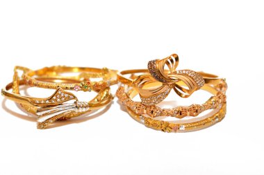 İzole edilmiş beyaz bir arka planda mücevher, bir dizi altın bilezik 21 karat tasarım altın mücevherler, değerli metal takılar, seçici bir odak noktası olan bileklik.