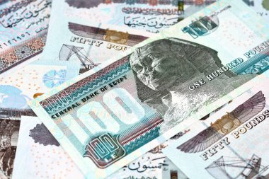 100 LE, 50 LE 'lik Mısır para banknotları yığını, 100 Pound ve 50 Pound' luk yığının seçici odak noktası Sultan Hassan, Abu Hurayba camileri, Sfenks ve Edfu Tapınağı 'dır.