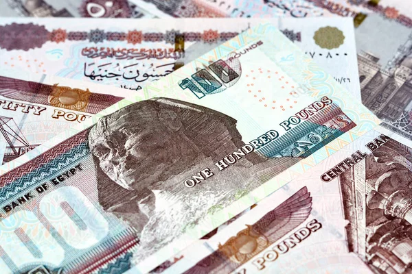 100 LE, 50 LE 'lik Mısır para banknotları yığını, 100 Pound ve 50 Pound' luk yığının seçici odak noktası Sultan Hassan, Abu Hurayba camileri, Sfenks ve Edfu Tapınağı 'dır.