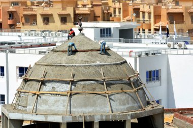 Kahire, Mısır, 6 Nisan 2021: Mısır 'da bir cami inşa eden inşaat işçileri, yeni bir cami inşaatında, çelik, beton ve betondan yapılmış kubbe üzerine seçici bir odak noktası.
