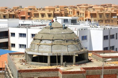 Kahire, Mısır, 6 Nisan 2021: Mısır 'da bir cami inşa eden inşaat işçileri, yeni bir cami inşaatında, çelik, beton ve betondan yapılmış kubbe üzerine seçici bir odak noktası.