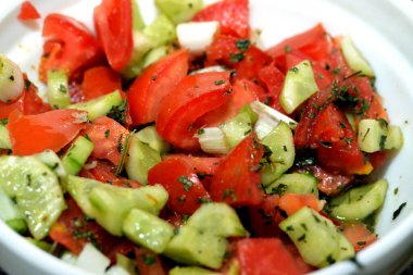Geleneksel Arap yeşil salatası, salatalık, domates ve yeşil soğanın karışımı, taze sebze parçaları, sağlıklı yiyecek ve diyet konsepti, seçici odaklanma.
