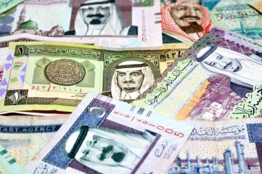 Bir yığın Suudi Arabistan riyalistinin geçmişi farklı zamanlardan gelen farklı değerlere sahip para banknotları, Suudi Arabistan krallığının seçici odak noktası, Suudi Arabistan ekonomisi konsepti