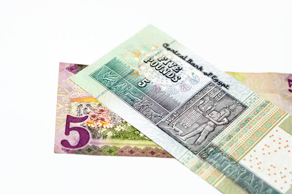 Reverse sides of Saudi Arabia 5 five riyals banknote with 5 LE five Egyptian pounds bill isolated on a white background, Selective focus of Egyptian and Saudi money exchange rate