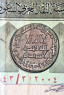 Eski bir Suudi Arabistan banknotunun ters tarafından Arapça bir metne yakın plan, çeviri (yalnız Allah 'tan başka tanrı yoktur, ortağı yoktur), antika eski Suudi parası