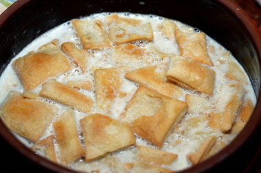 Mısır ekmeği pudingi üzerine süt, sütten yapılmış kahverengi çanak çömlek güveci, doğranmış hindistan cevizli Mısır ekmeği roqaq, geleneksel Arap Mısırlı Doğu tatlı mutfağı Om Ali