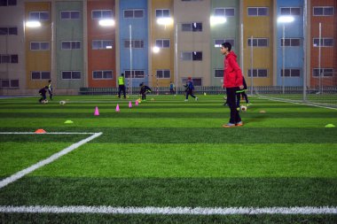 Kahire, Mısır, 3 Şubat 2018: Bir futbol sahasında futbol maçı öncesi egzersiz yapan bir grup genç çocuk oyuncu, çocukların becerilerini ve futbol eğitimini geliştirmek için futbol antrenmanı