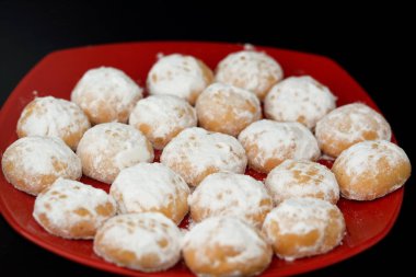 El-Fitr bayramını kutlamak için geleneksel Arap kurabiyeleri, pudra şekerle kaplanmış Mısır kahvesi ve içi ceviz ve fındık dolu siyah arka planda izole edilmiş