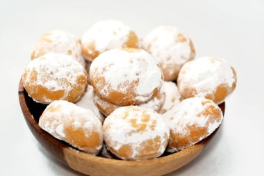 Geleneksel Arap kurabiyeleri El-Fitr bayramını kutlamak için, Mısır kahvesi pudra şekerle kaplanmış, içi ceviz dolu ve beyaz üzerine izole edilmiş tahta bir tabakta.