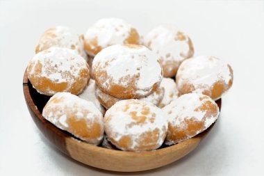 Geleneksel Arap kurabiyeleri El-Fitr bayramını kutlamak için, Mısır kahvesi pudra şekerle kaplanmış, içi ceviz dolu ve beyaz üzerine izole edilmiş tahta bir tabakta.