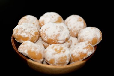 El-Fitr bayramını kutlamak için geleneksel Arap kurabiyeleri, pudra şekerle kaplanmış Mısır kahvesi ve içi ceviz ve fındık dolu siyah arka planda izole edilmiş