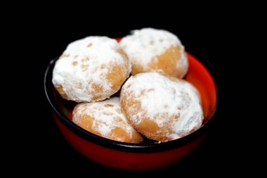 Geleneksel Arap kurabiyeleri El-Fitr bayramını kutlamak için, Mısır kahvesi pudra şekerle kaplanmış, ceviz ve fındık ile doldurulmuş ve siyah bir tabakta izole edilmiş kırmızı tabakta.