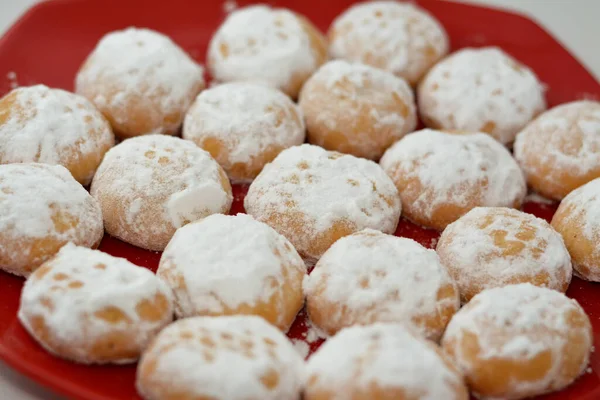 エルフィトル祭のイスラム教の休日を祝うための伝統的なアラビアのクッキー 粉末砂糖で覆われたエジプトのカフクと詰め物をし 赤いセラミックプレートにクルミとナッツでいっぱい — ストック写真