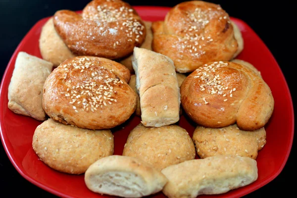 埃及东部的阿拉伯美食 饼干里塞满了椰枣糊 芝麻和糖的饼干 开斋节 斋月糖果和甜点 放在用黑色隔开的红盘上 — 图库照片