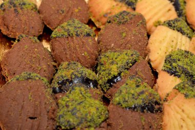 El-Fitr bayramını kutlamak için geleneksel Arap kurabiyeleri yığını, reçel ve fındıkla doldurulmuş ve çikolata ve şam fıstığı ile kaplanmış dört küçük fırın (mignardises).