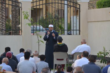 Kahire, Mısır, 2 Mayıs 2022: Bir cami vaizi, yaygınlık yasağı sona erdikten sonra cami yakınlarındaki açık hava sahasında Kurban İmam El Fitr Khutbah 'ı (vaaz) sahneledi, İslami kahvaltı namazı ve kutlama duası yaptı
