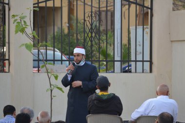 Kahire, Mısır, 2 Mayıs 2022: Bir cami vaizi, yaygınlık yasağı sona erdikten sonra cami yakınlarındaki açık hava sahasında Kurban İmam El Fitr Khutbah 'ı (vaaz) sahneledi, İslami kahvaltı namazı ve kutlama duası yaptı