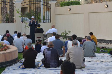 Kahire, Mısır, 2 Mayıs 2022: Bir cami vaizi, yaygınlık yasağı sona erdikten sonra cami yakınlarındaki açık hava sahasında Kurban İmam El Fitr Khutbah 'ı (vaaz) sahneledi, İslami kahvaltı namazı ve kutlama duası yaptı