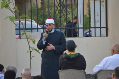Kahire, Mısır, 2 Mayıs 2022: Bir cami vaizi, yaygınlık yasağı sona erdikten sonra cami yakınlarındaki açık hava sahasında Kurban İmam El Fitr Khutbah 'ı (vaaz) sahneledi, İslami kahvaltı namazı ve kutlama duası yaptı